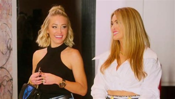 Mary Fitzgerald and Chrishell Stause from 'Selling Sunset' sit poolside