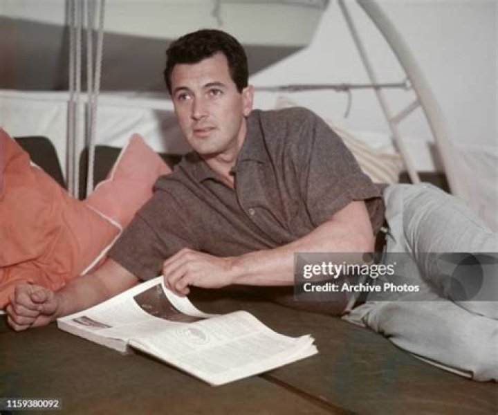 Rock Hudson lounging and reading a book in 1955